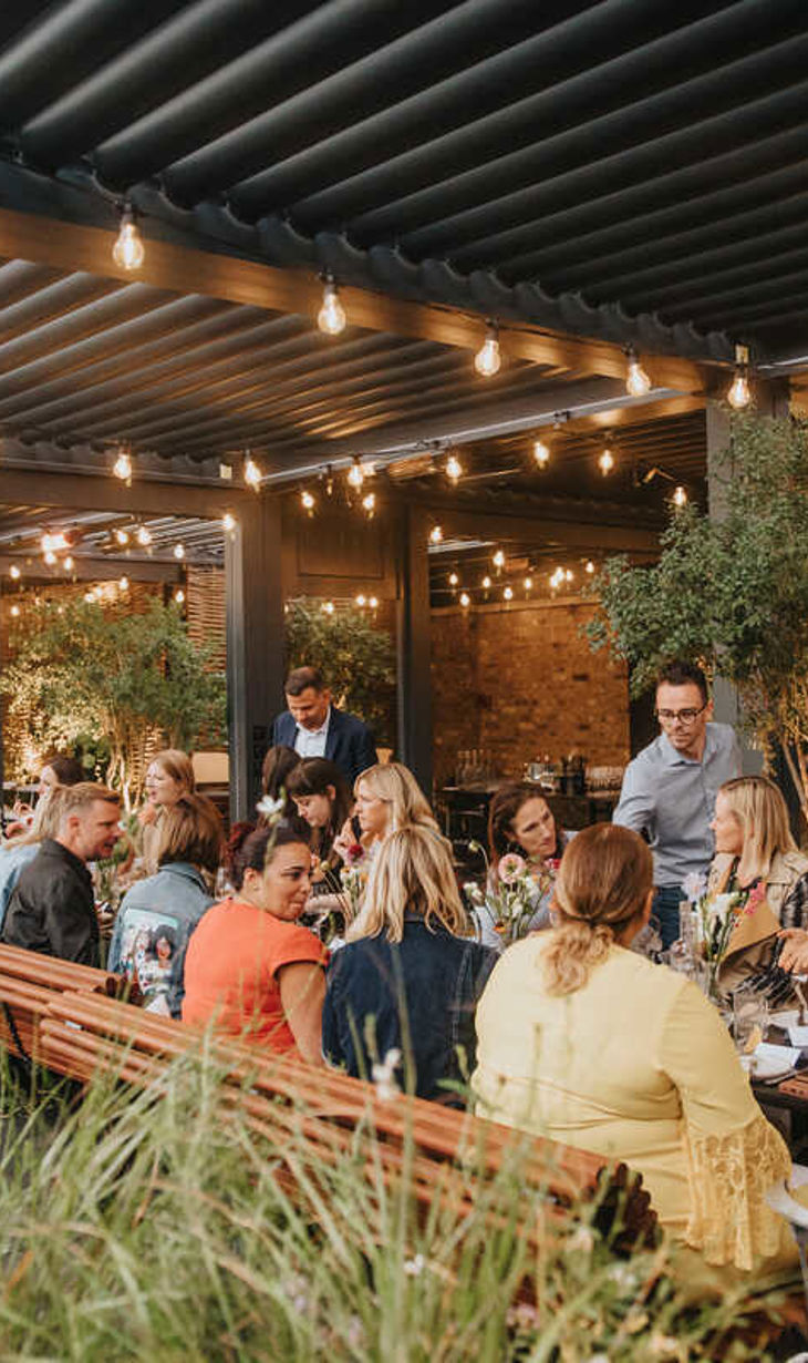 Guests sitting at beautifully lit venue enjoying food and drink