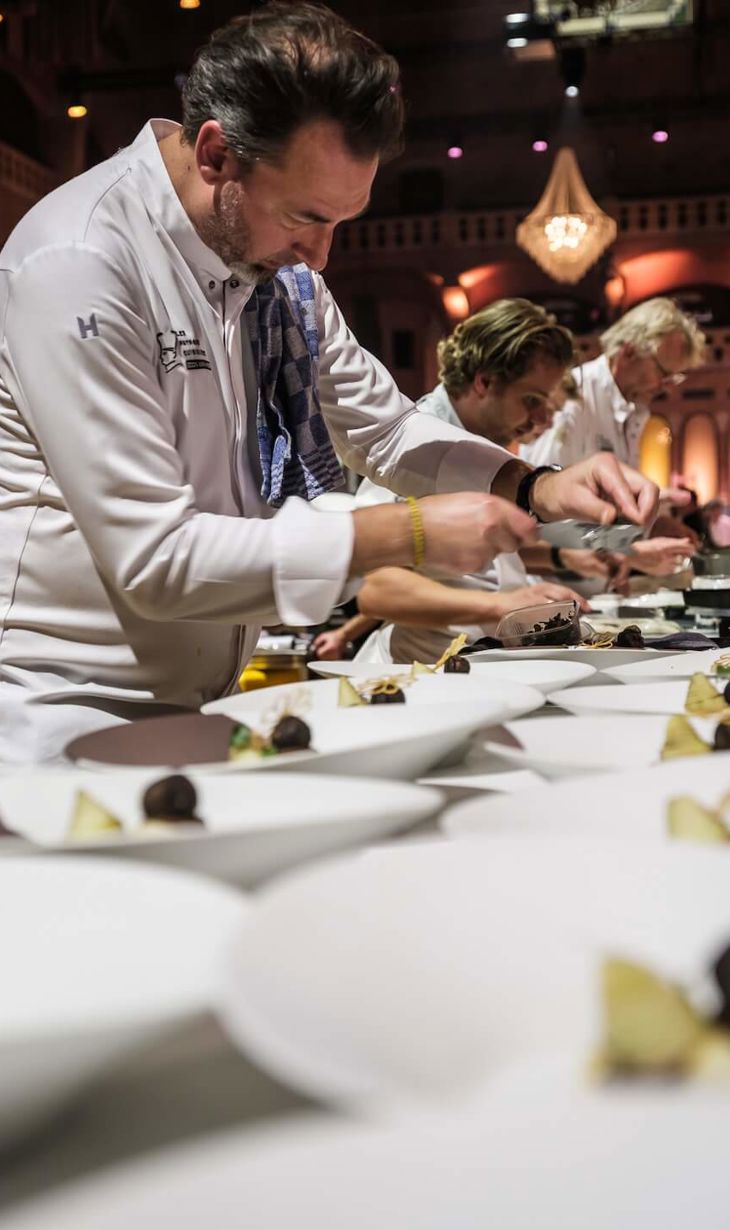 Chefs plating up premium food in a line